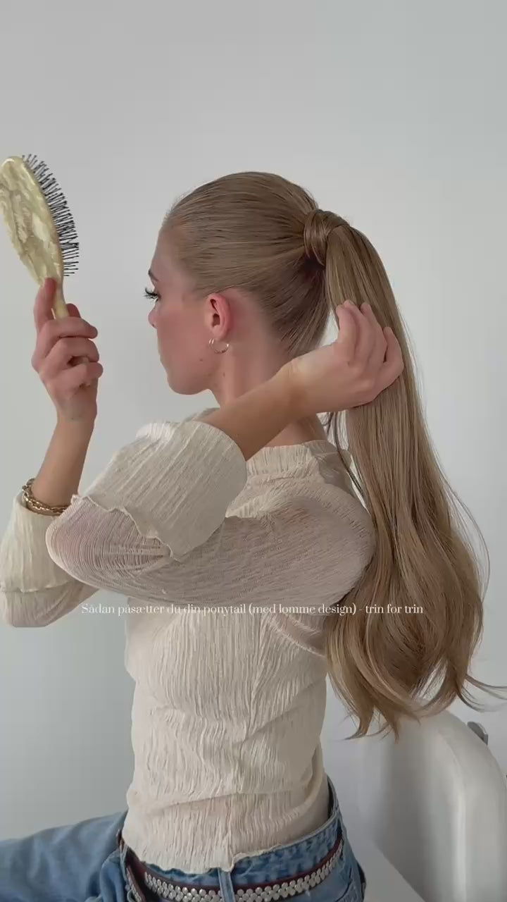 Load video: A girl showing how to put on our Victoria ponytail with pocket design